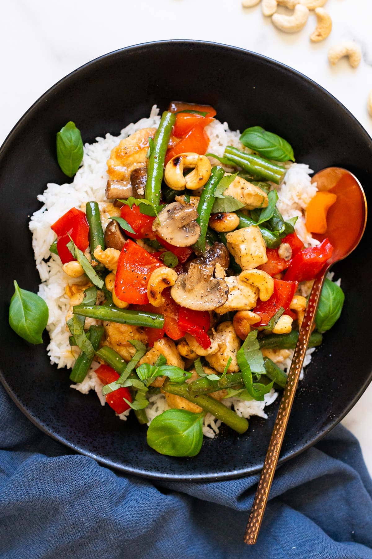 Cash or chicken served over rice in a bowl with a spoon.