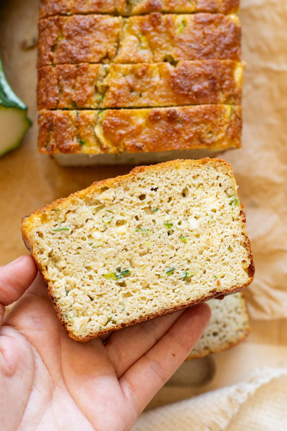 Person holding a slice of zucchini bread with cottage cheese.