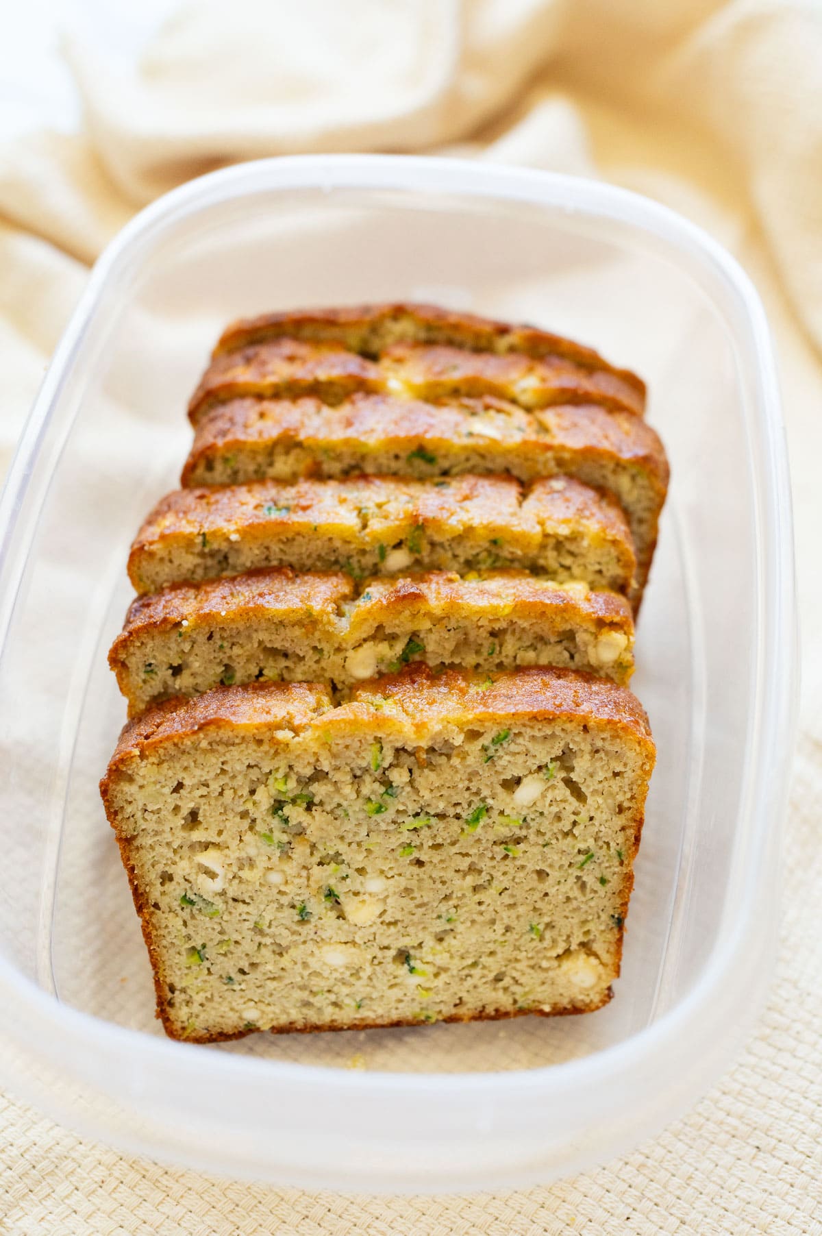 Slices of cottage cheese zucchini bread in a plastic container.