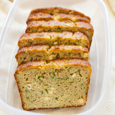 Slices of cottage cheese zucchini bread in a plastic container.