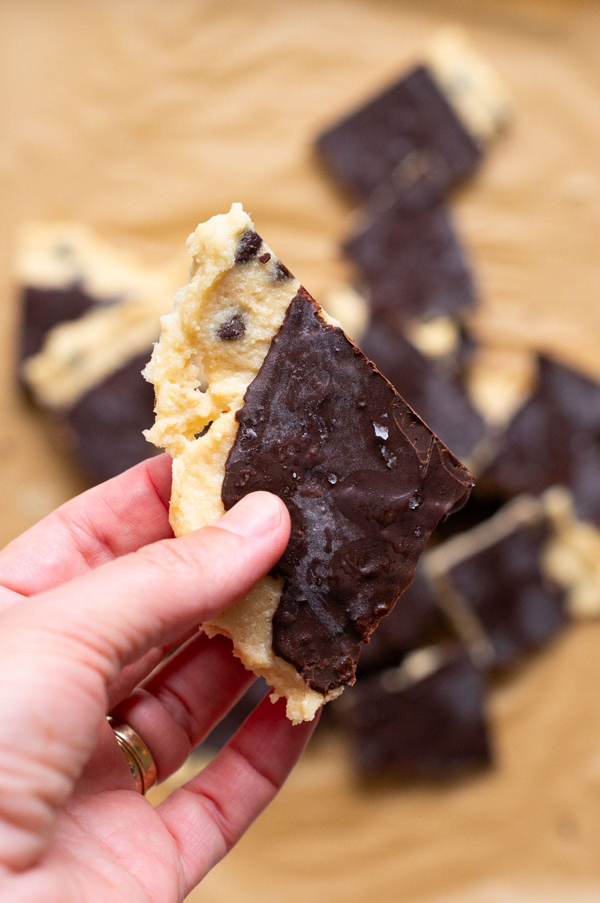 Person holding a slice of cookie dough bark.