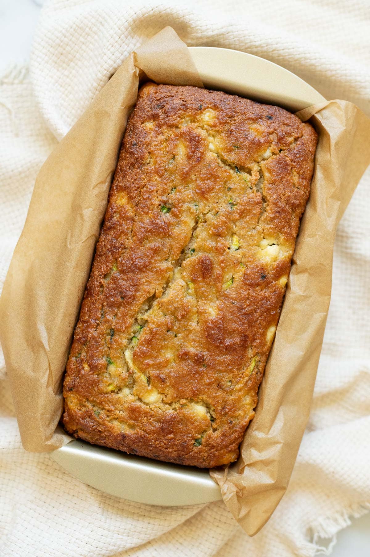 Cottage cheese zucchini bread in a loaf pan lined with parchment paper.