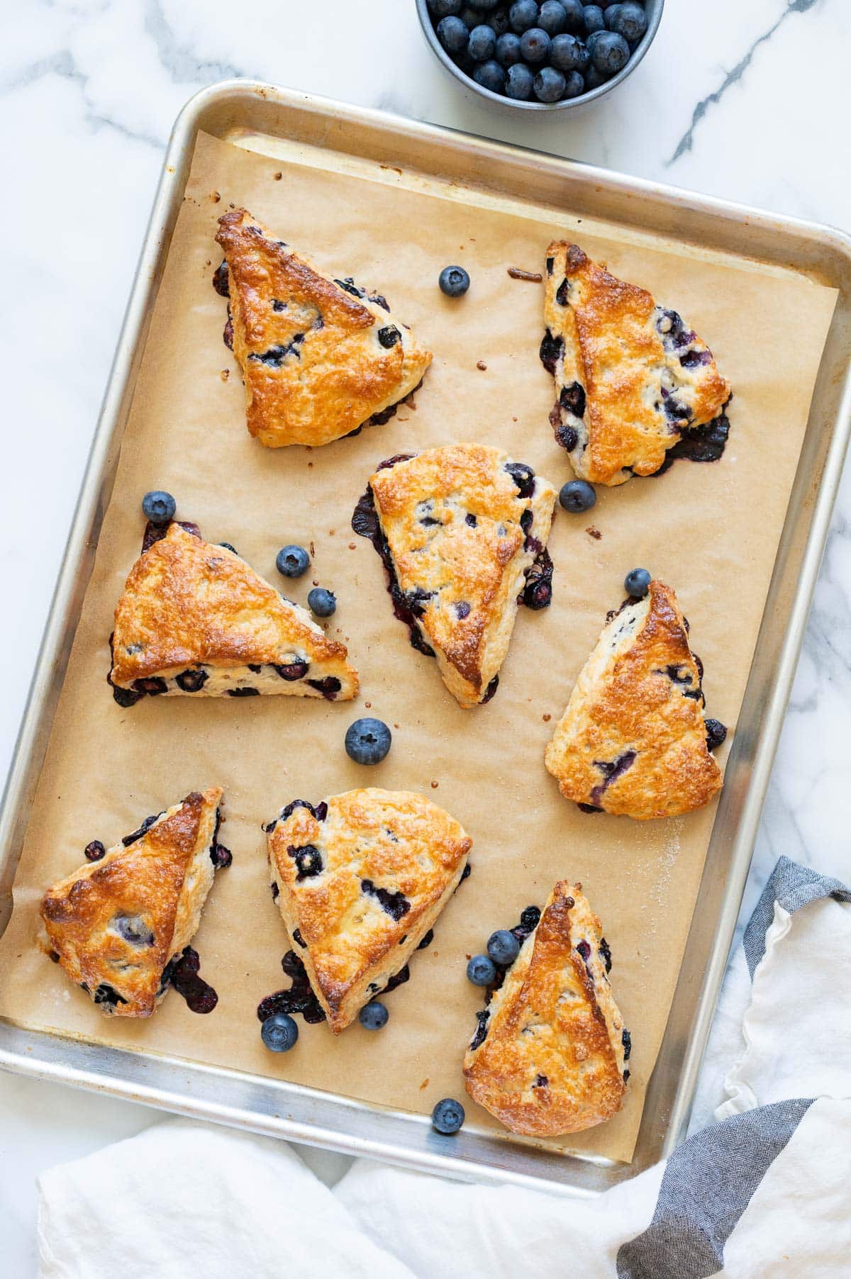 Scones with Greek yogurt and blueberries on a baking sheet.