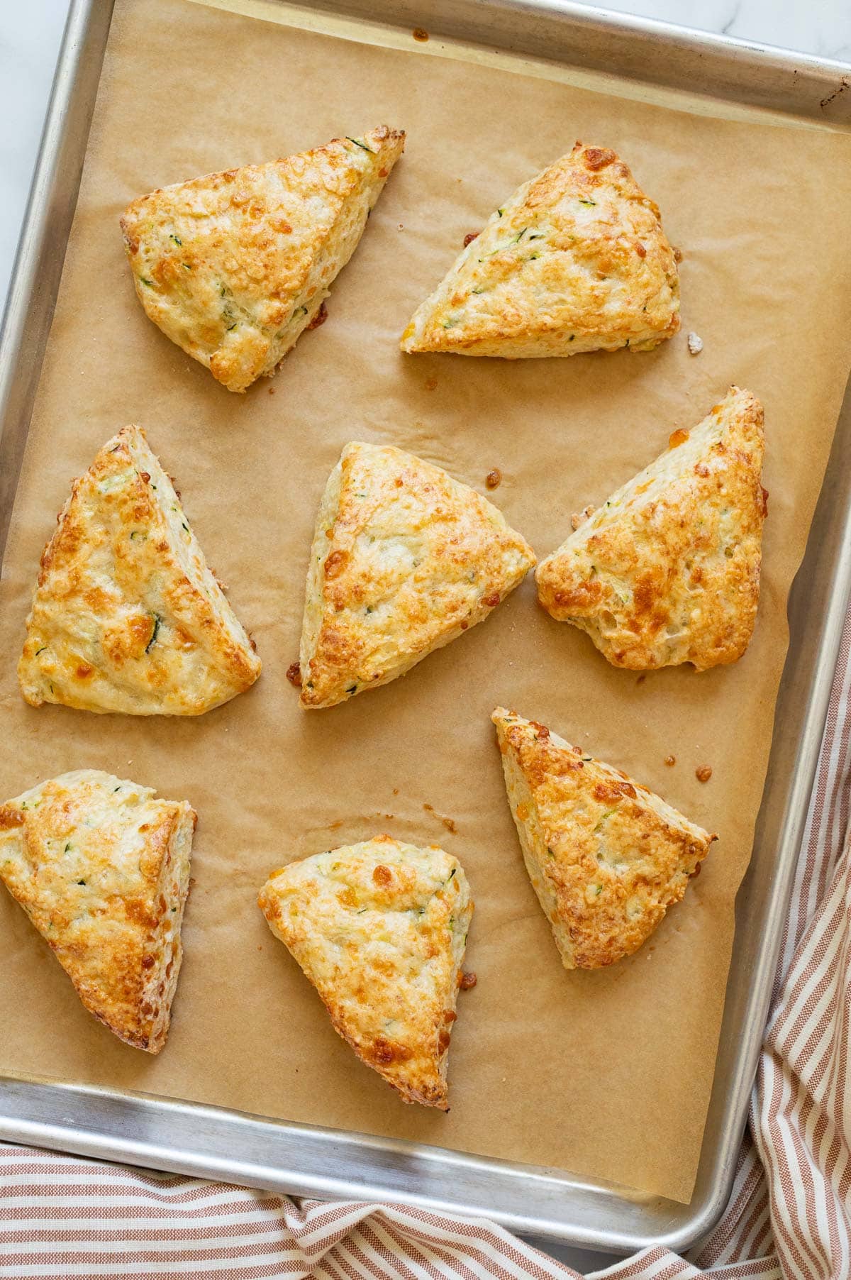 Eight scones on a baking sheet lined with parchment paper.