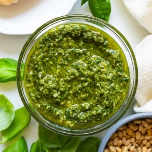 Fresh basil pesto sauce in a glass jar.