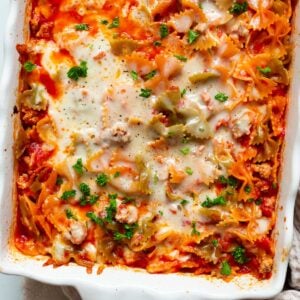 No boil pasta bake with melted cheese and parsley on top in baking dish.