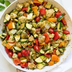 Pesto chicken and vegetables in a skillet.