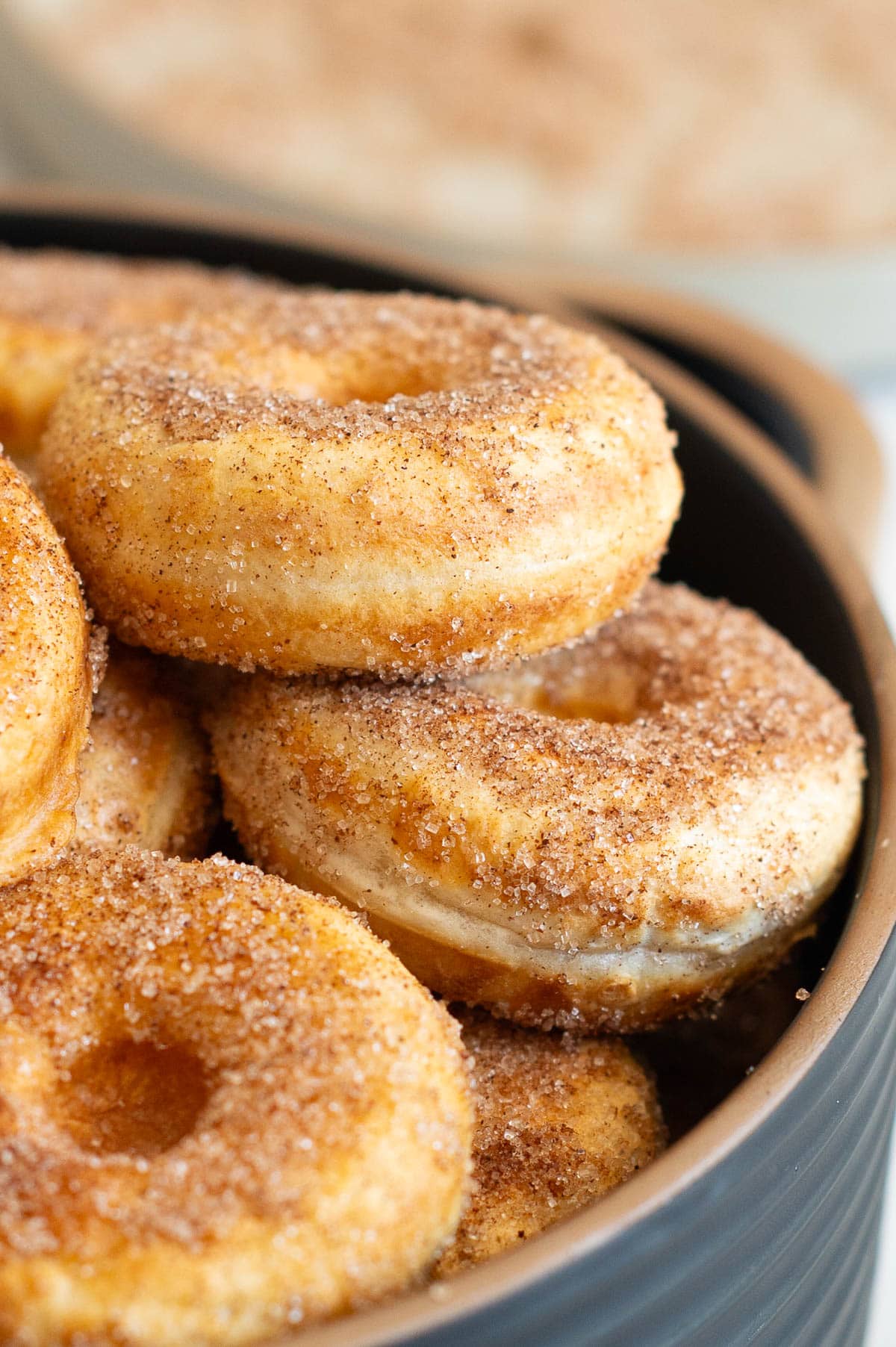 Close up side view of Greek yogurt donuts coated in cinnamon sugar.