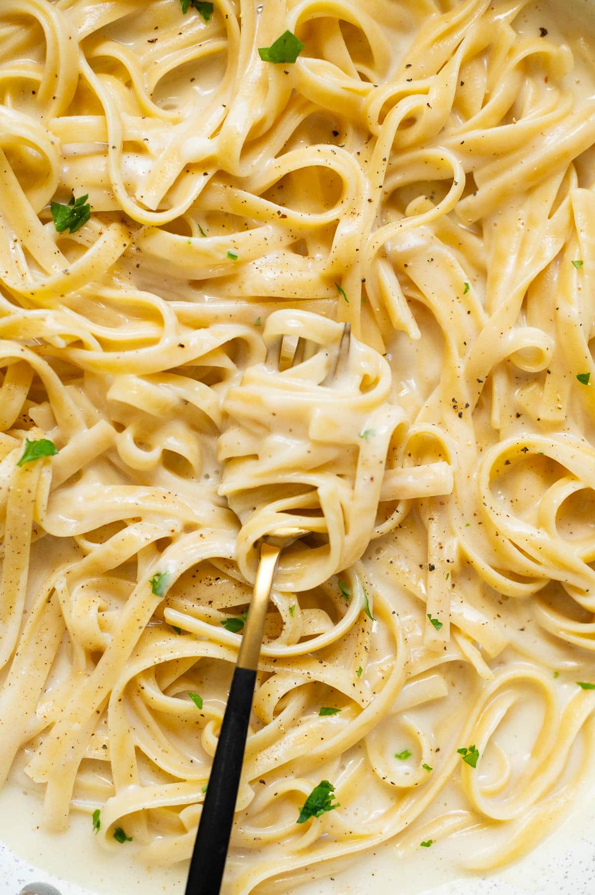 Close up of cottage cheese alfredo on a fork.