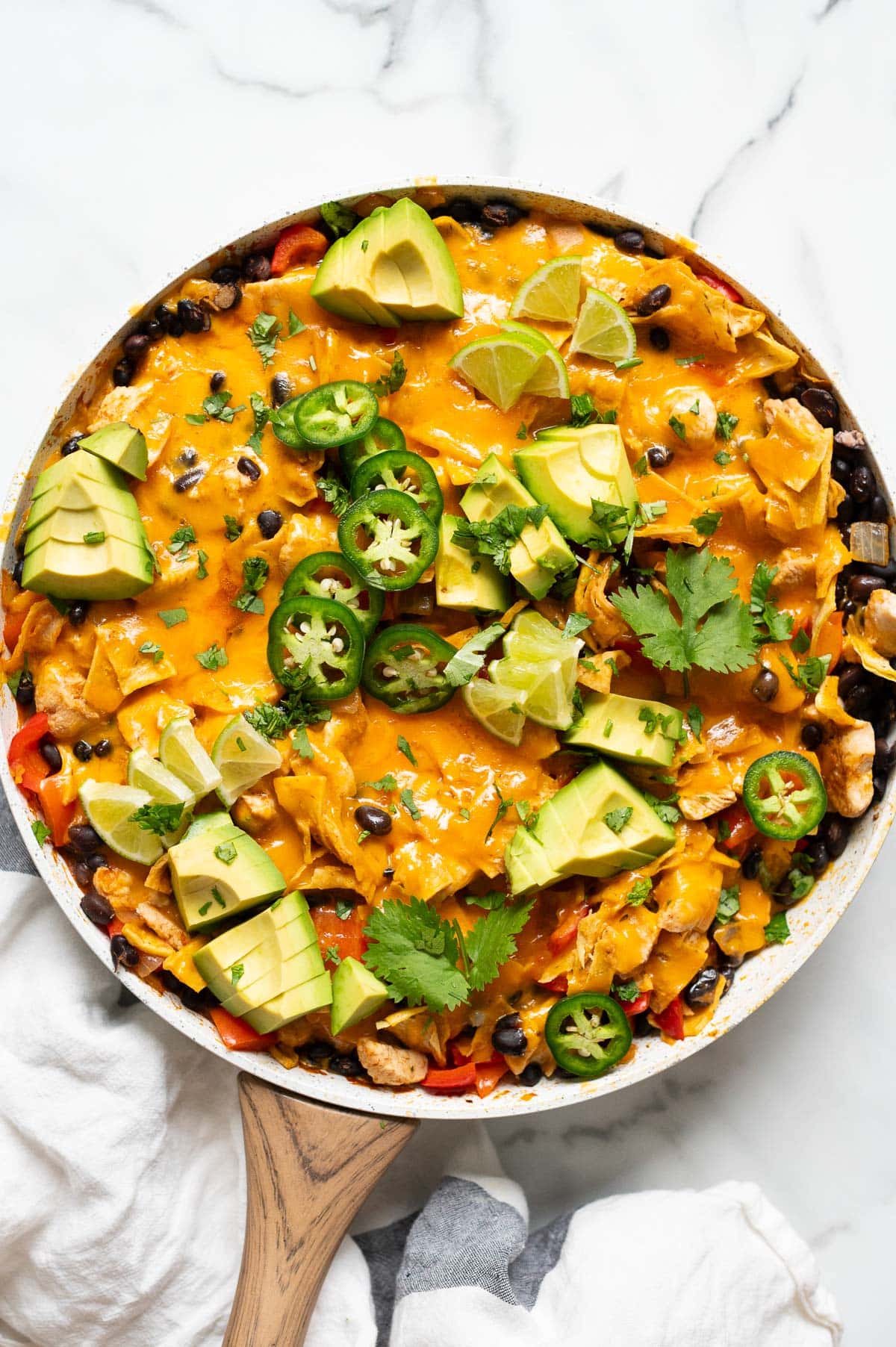 Chicken enchilada skillet with melted cheese, avocado, jalapenos and cilantro.