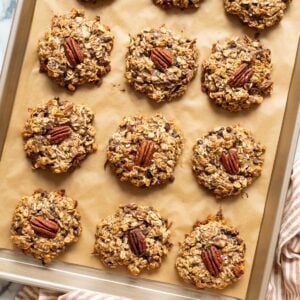 12 breakfast cookies garnished with pecans on a baking sheet.