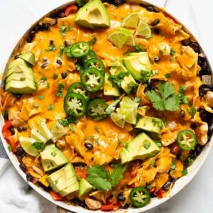 Chicken enchilada skillet with melted cheese, avocado, jalapenos and cilantro.