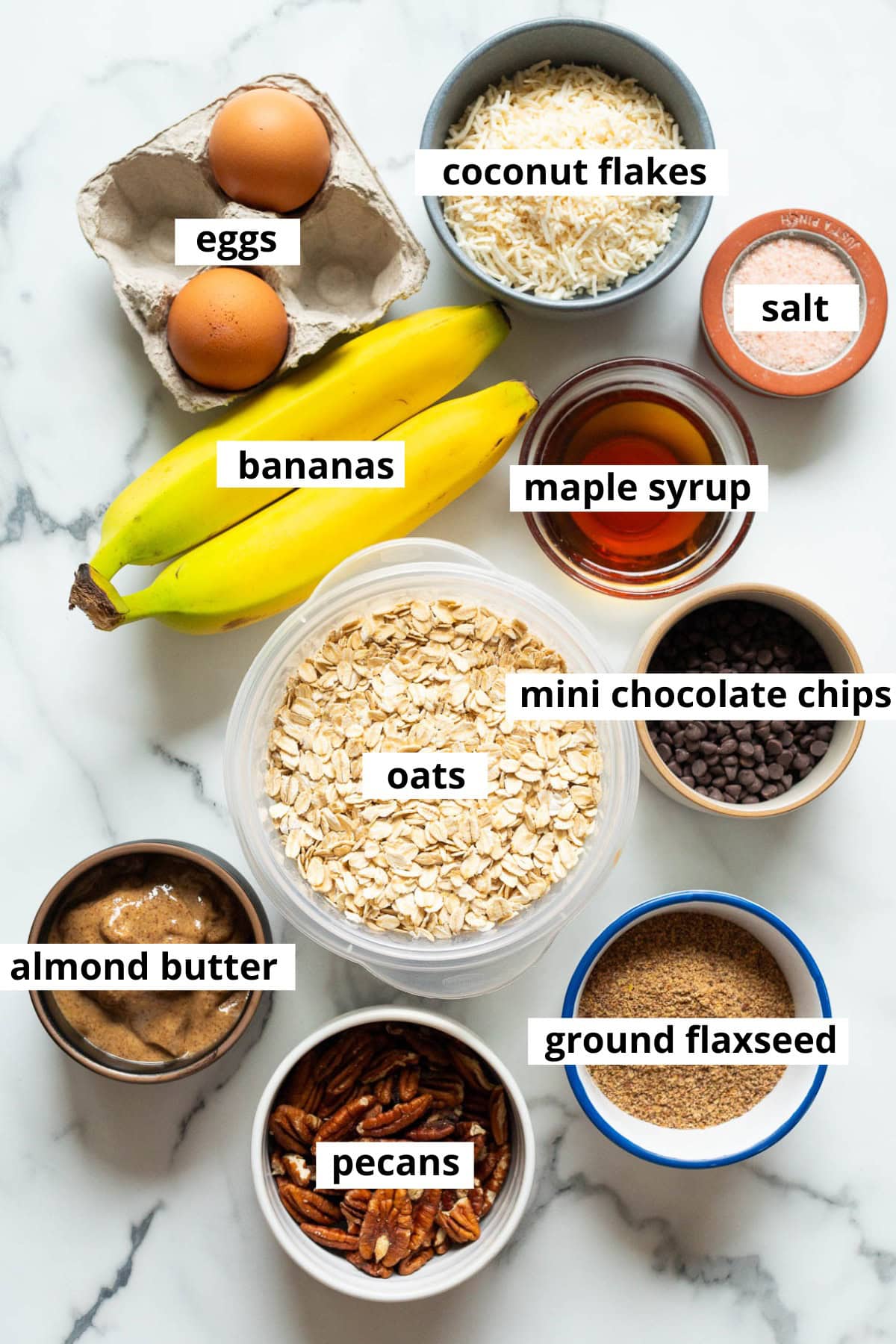 Oats, bananas, eggs, maple syrup, salt, coconut flakes, mini chocolate chips, ground flaxseed, pecans, almond butter.