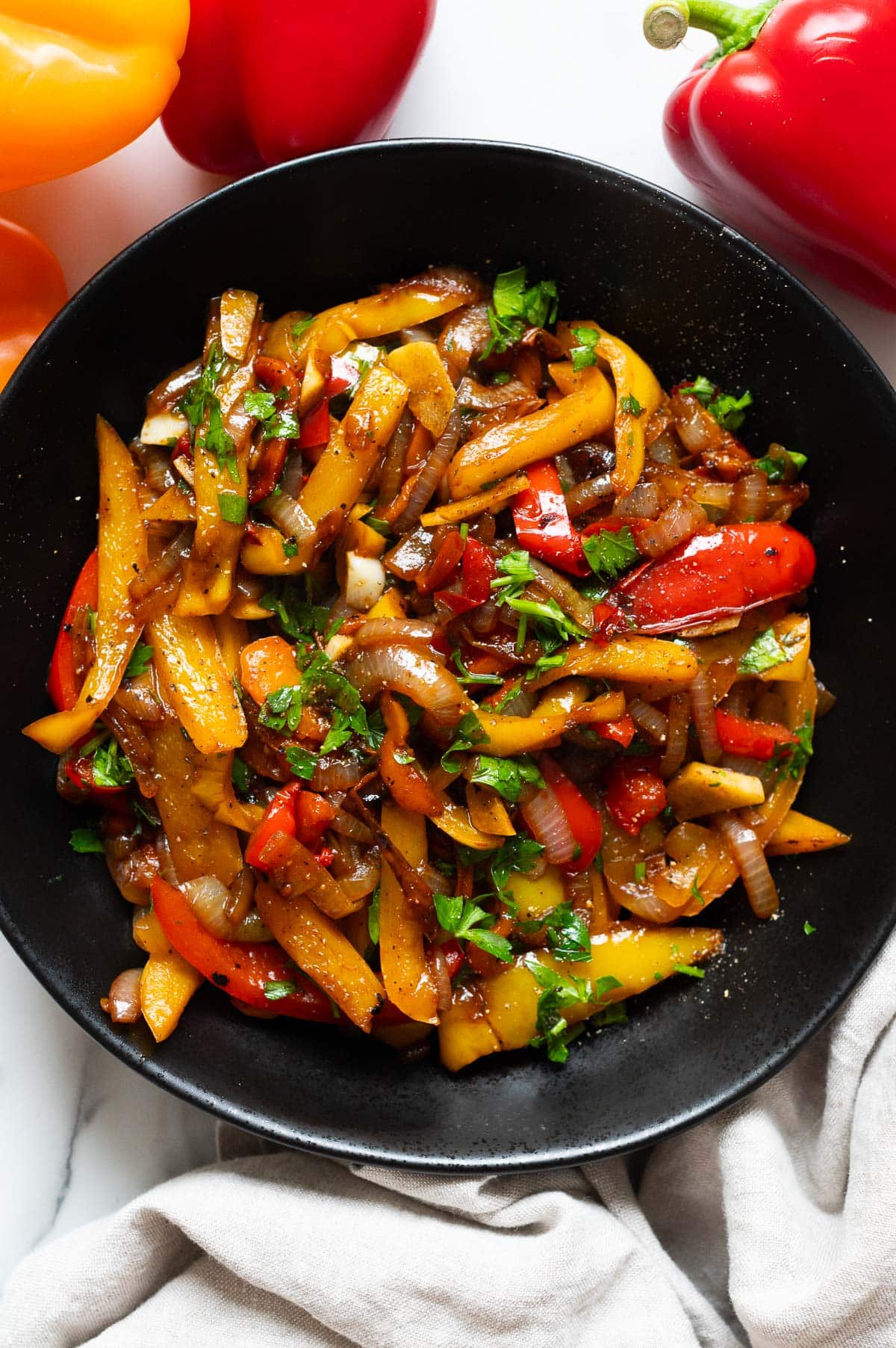 Sauteed red and yellow peppers and onions garnished with black pepper and parsley.