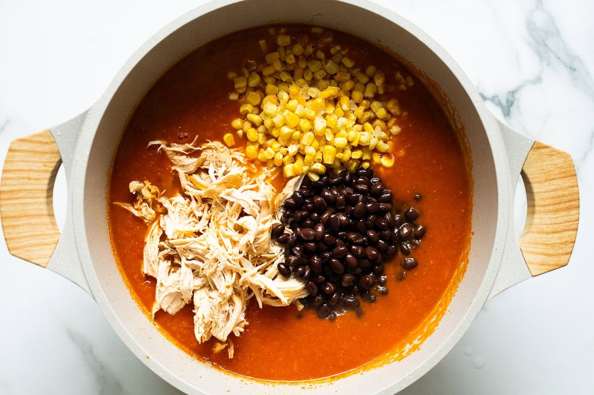 Shredded chicken, corn and black beans in a pot with creamed enchilada soup.