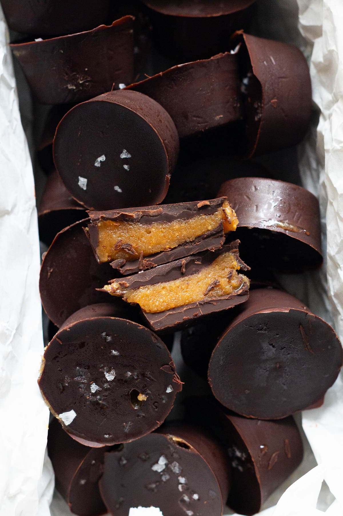 Two sliced healthy peanut butter cups on top of peanut butter cups in baking dish.