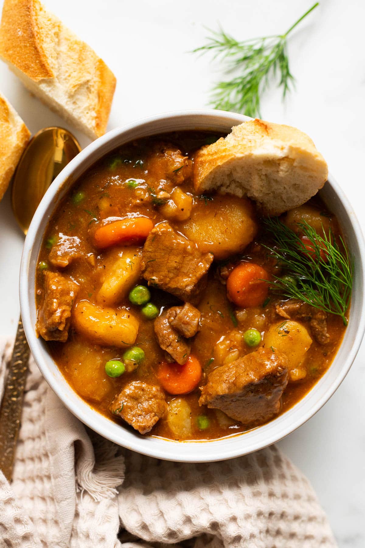 Beef stew served in a bowl with bread.