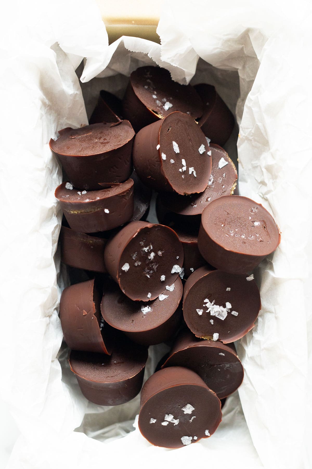 Homemade peanut butter cups sprinkled with sea salt in baking dish.