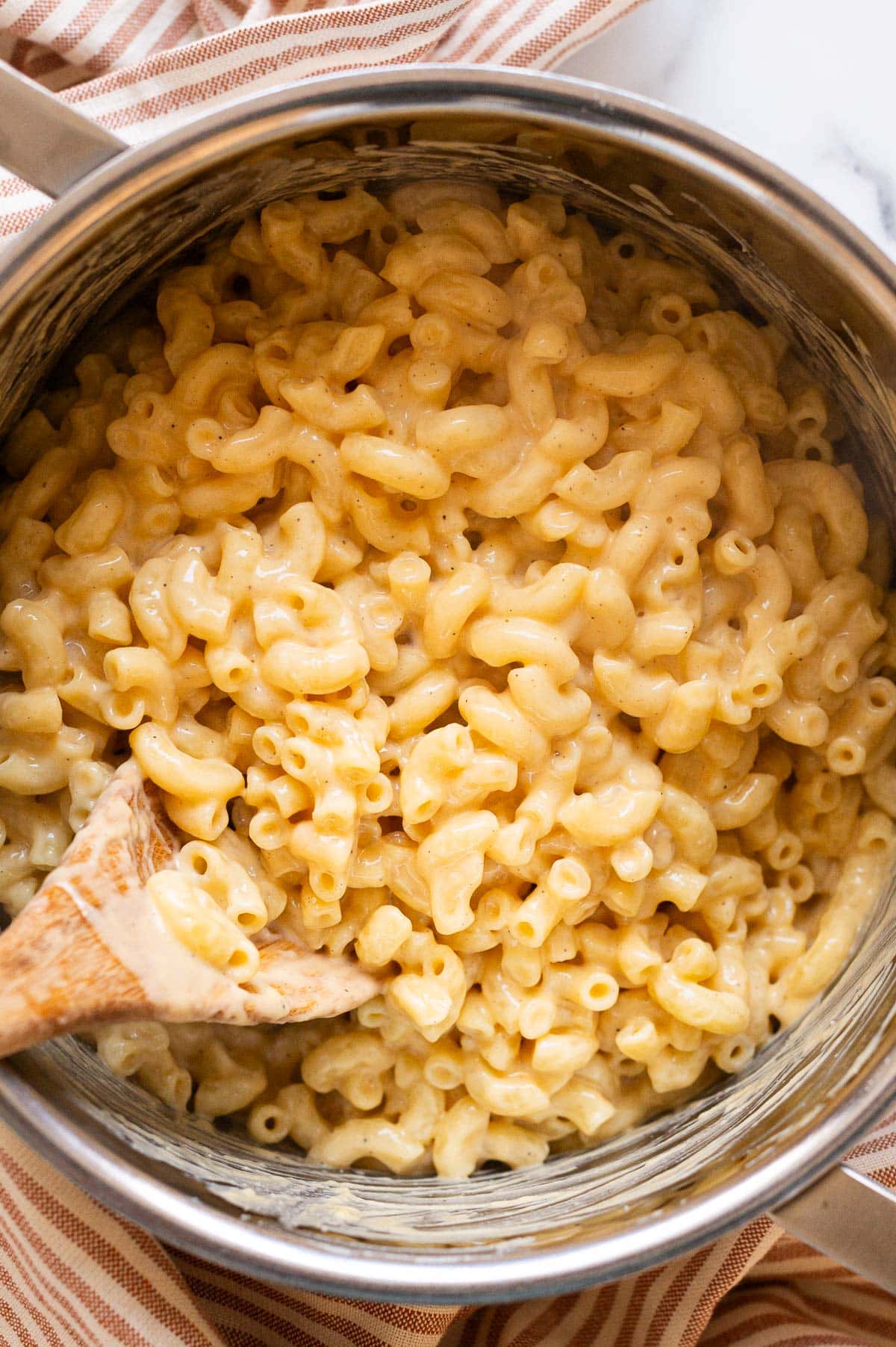 Cottage cheese mac and cheese in a pot with wooden spoon.