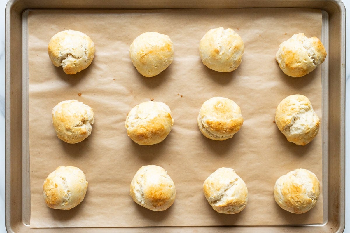 Baked dinner rolls on a baking sheet.