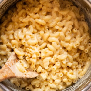 Cottage cheese mac and cheese in a pot with wooden spoon.