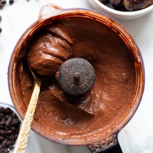 Hard boiled egg chocolate pudding in a food processor bowl scooped with a spoon.