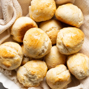 No yeast dinner rolls in a basket lined with kitchen towel.