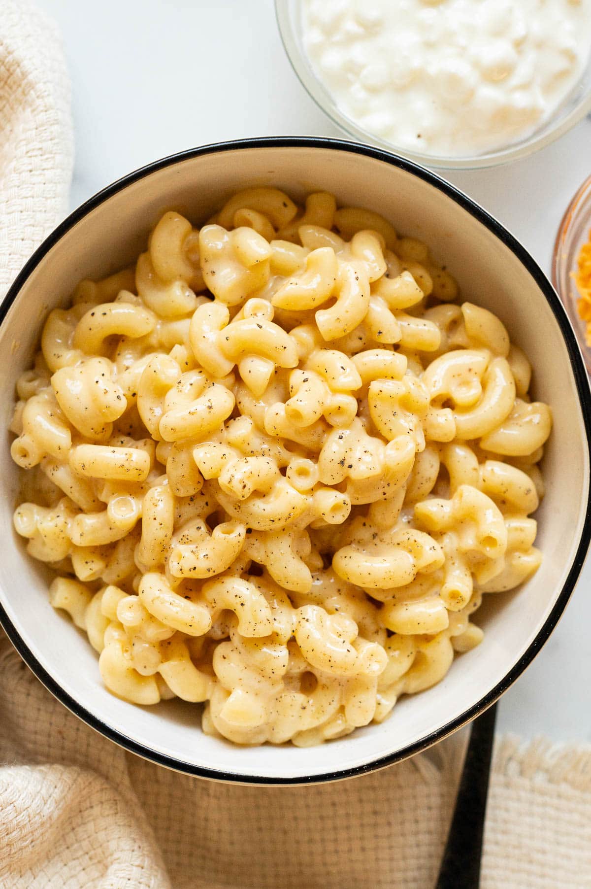 Mac and cheese garnished with black pepper in a bowl.