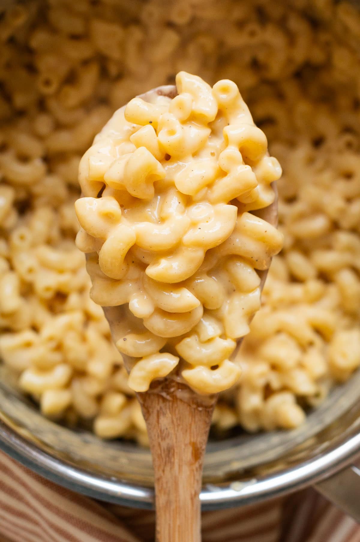 Closeup of high protein mac and cheese on a wooden spoon.