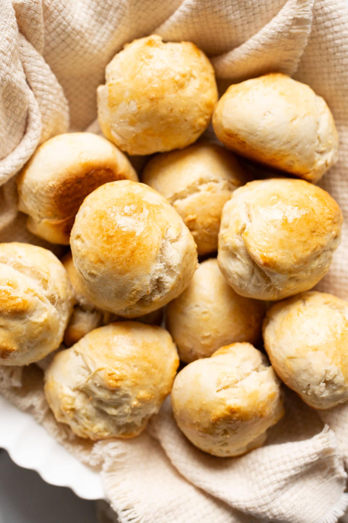 No yeast dinner rolls in a basket lined with kitchen towel.