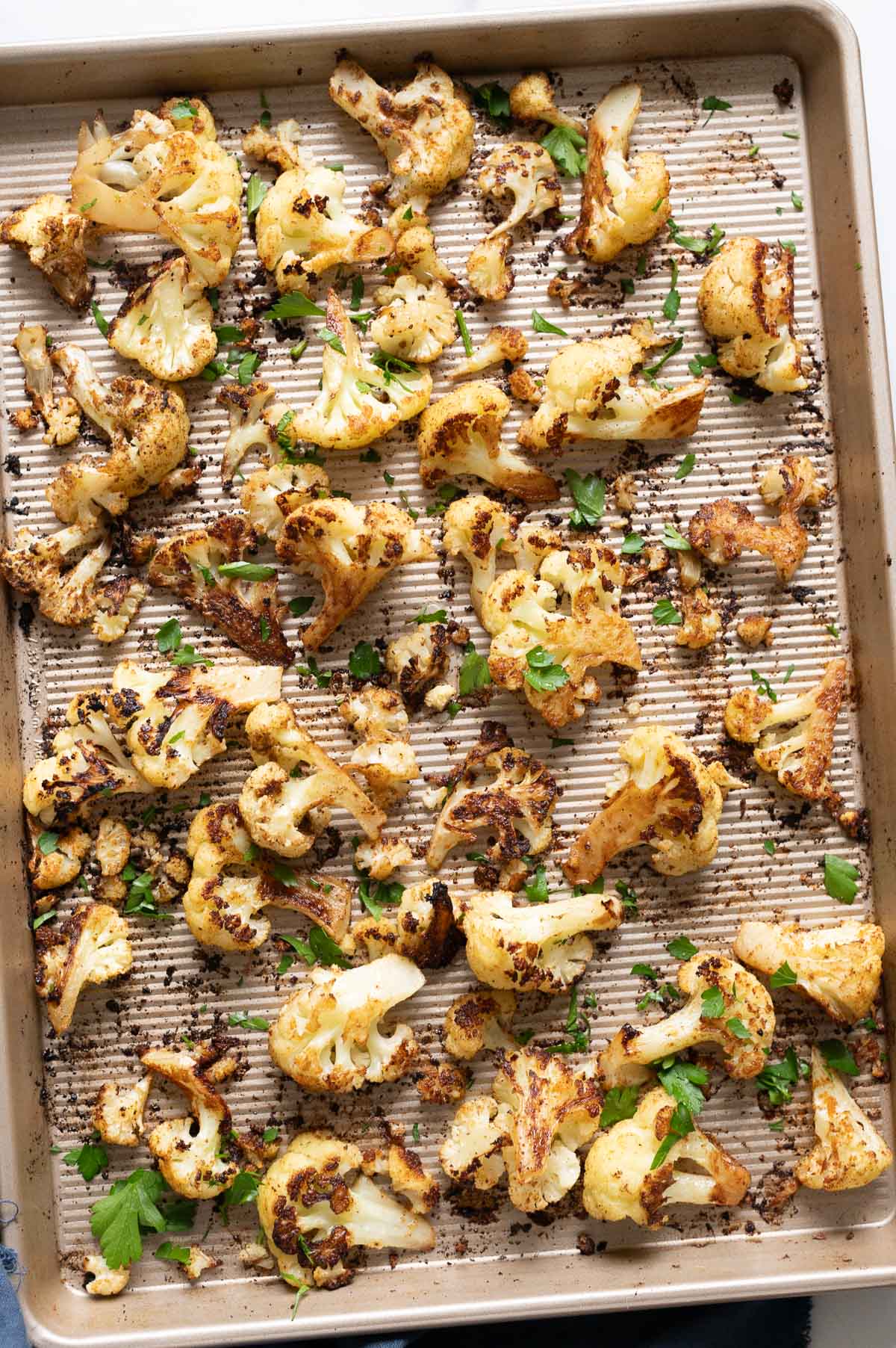 Roasted cauliflower florets on a baking sheet.