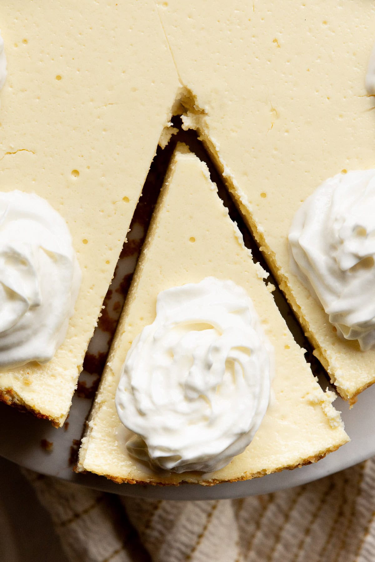 Looking down on a slice of cottage cheese cheesecake garnished with whipped cream.