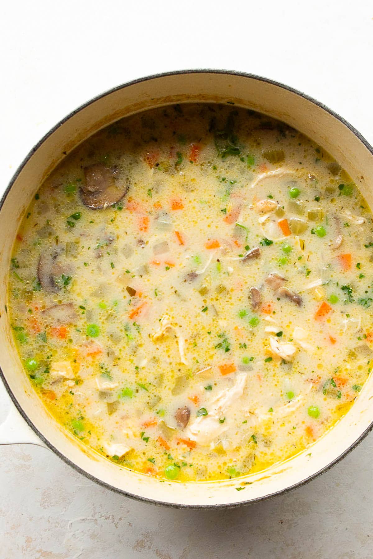 Cooked chicken pot pie soup in white pot.