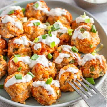 Buffalo chicken meatballs with blue cheese sauce on a plate.