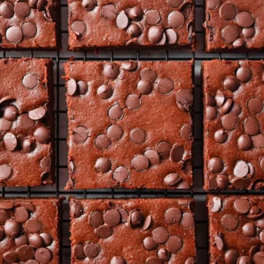 Sliced cottage cheese brownies on a wire rack.