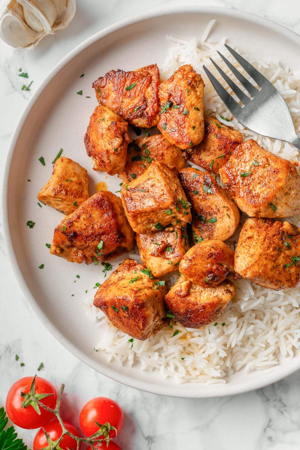 Close up of chicken bites garnished with parsley.