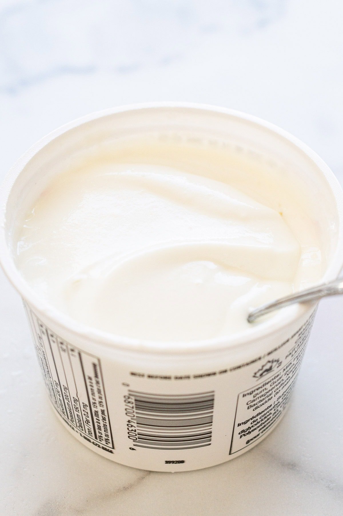 Whipped cottage cheese in a tub with a spoon.