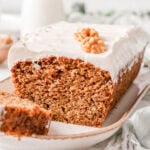 Carrot cake loaf with cream cheese frosting on a plate.