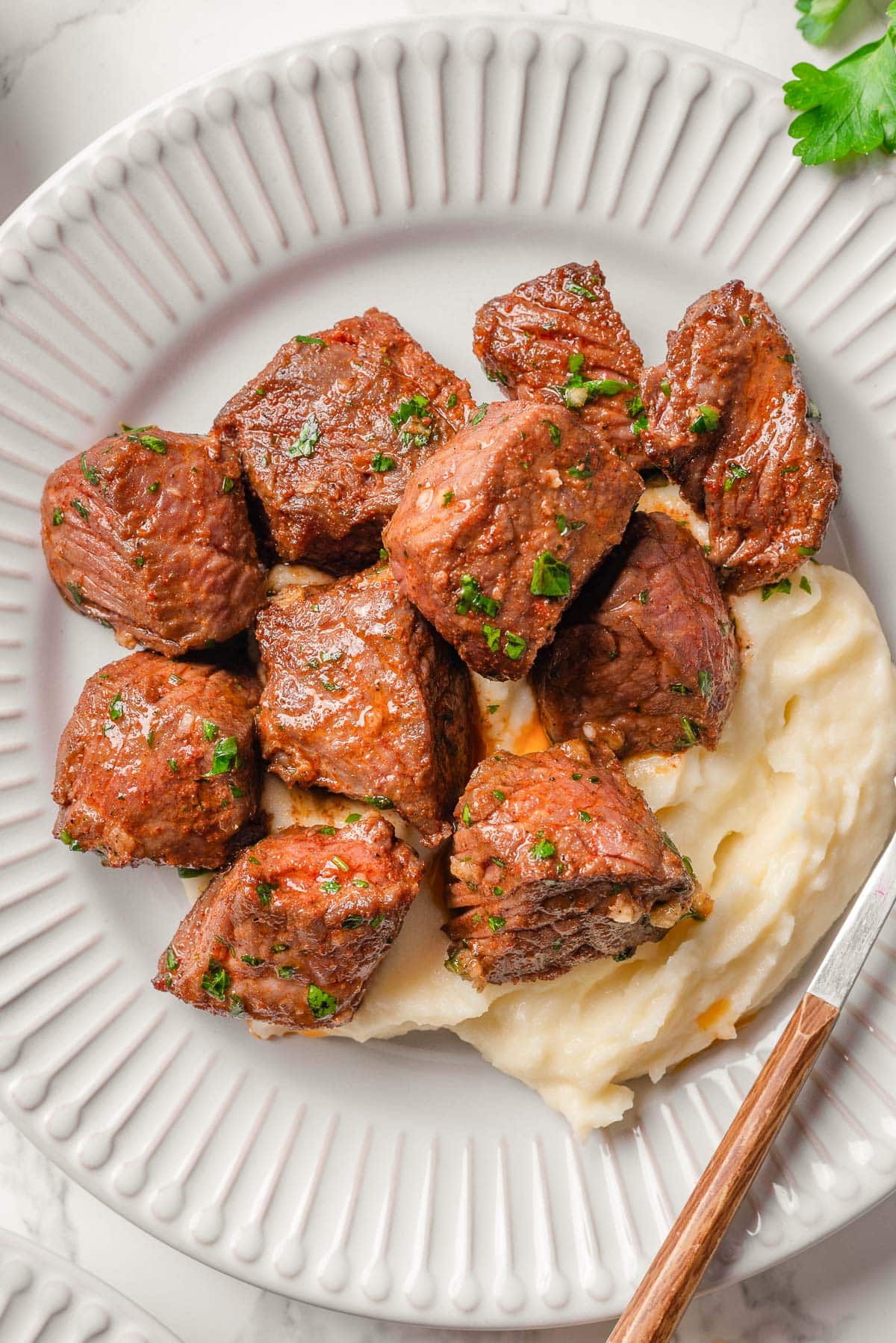 Air fryer steak bites served with mashed potatoes.