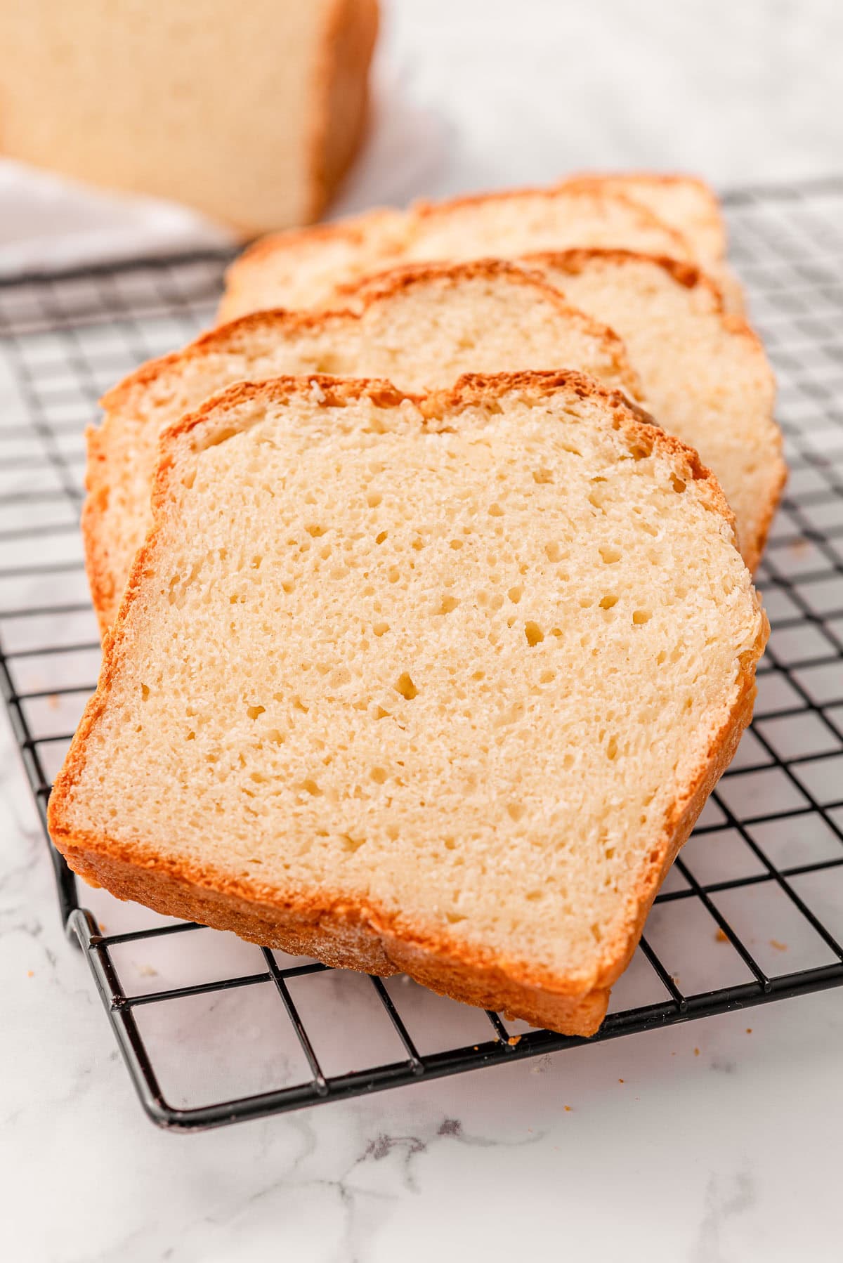 Sliced 2 ingredient bread on a wire rack.