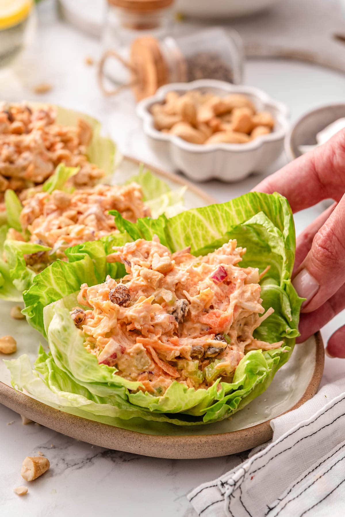 Buffalo chicken salad in lettuce wraps on a platter.