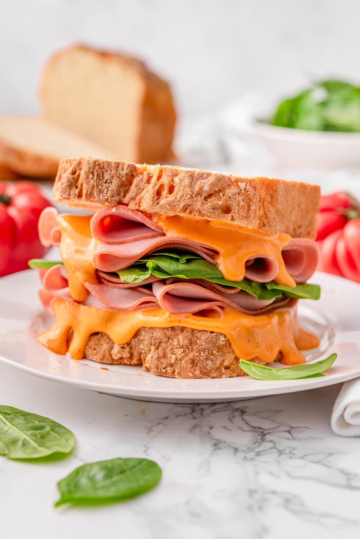 Sandwich with 2 ingredient bread, mortadella, lettuce and sriracha mayo.