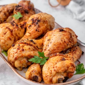 Baked chicken drumsticks on a platter.