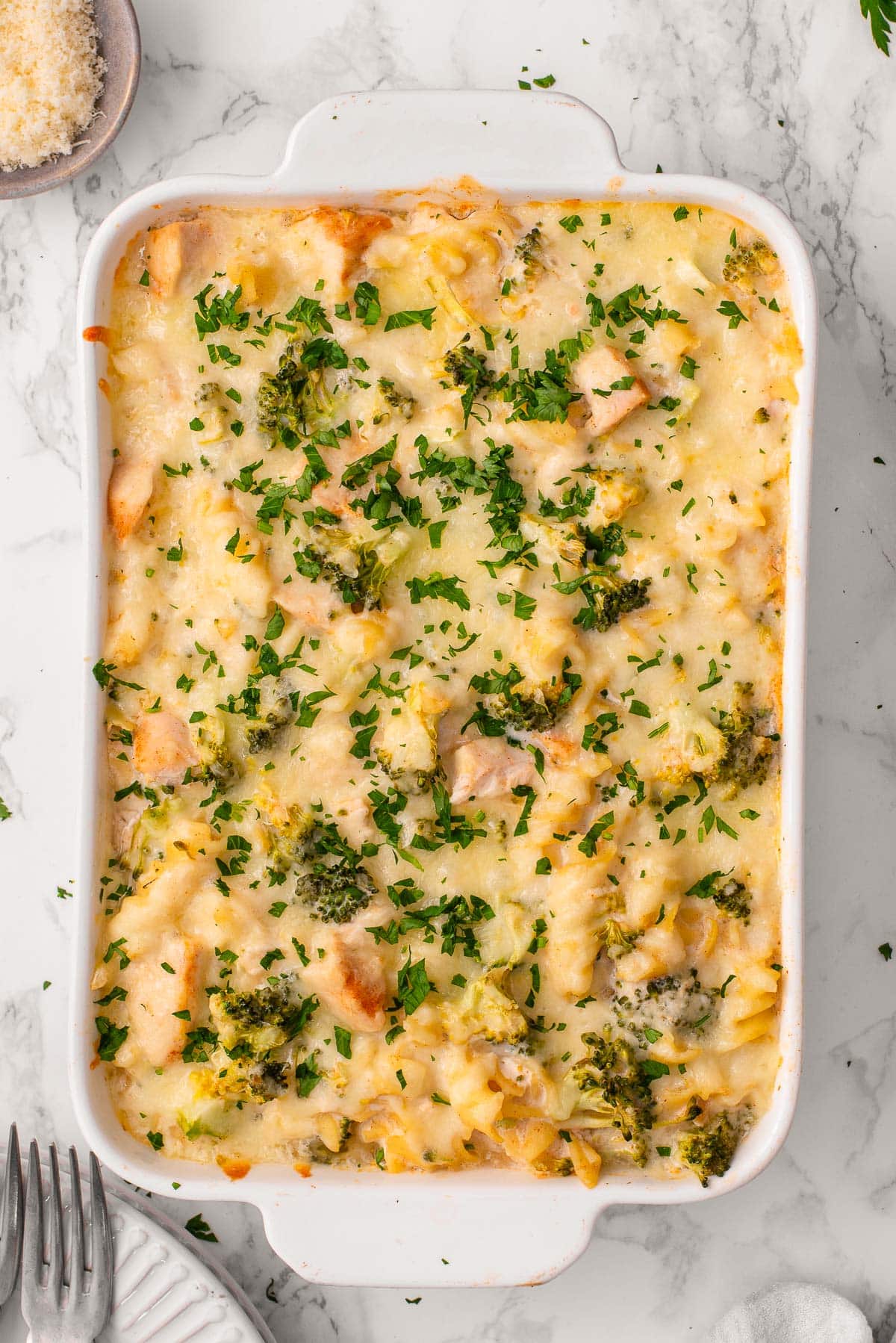 Baked chicken alfredo garnished with parsley.