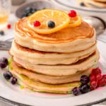 Greek yogurt pancakes stack with lemon and berries on top.