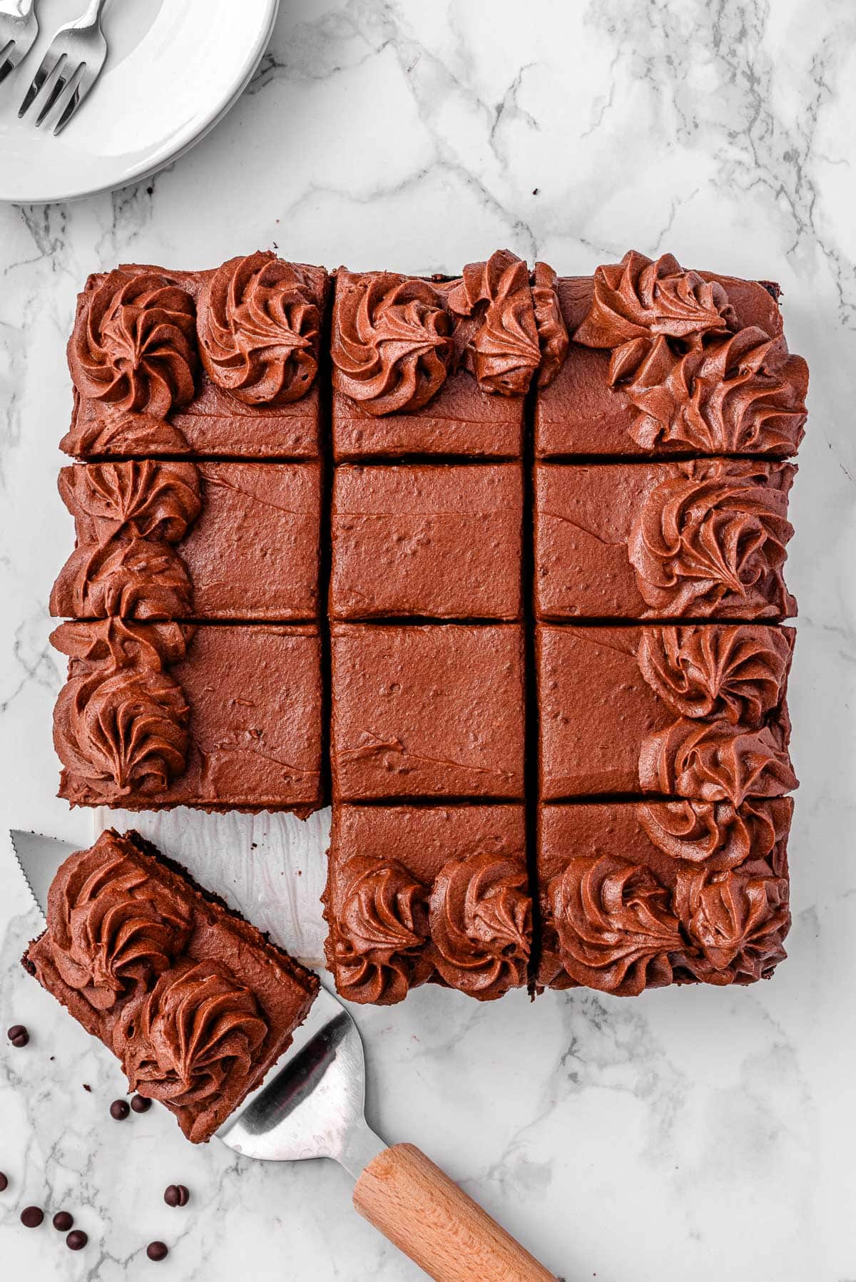 Healthy chocolate zucchini cake on a counter with one slice served.