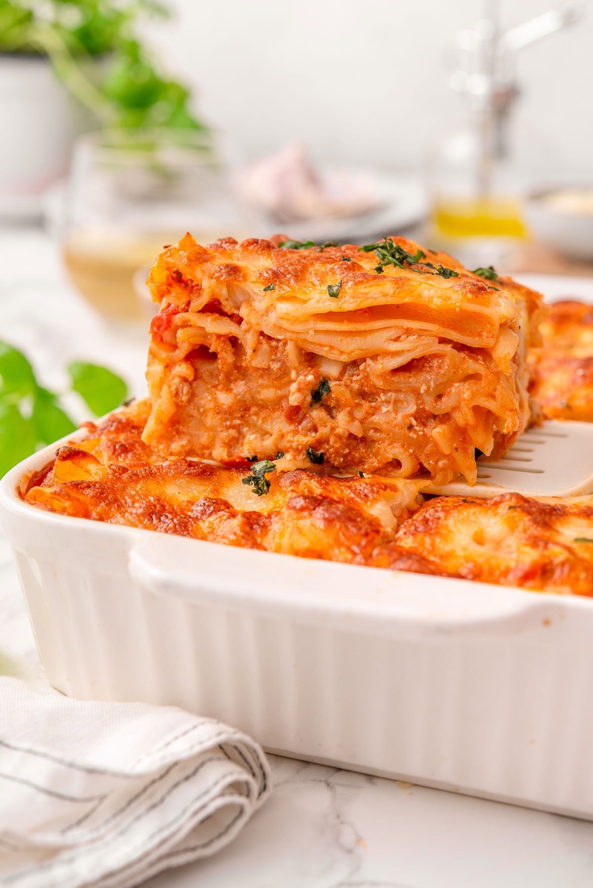 High protein baked ziti on a spatula in a baking dish.