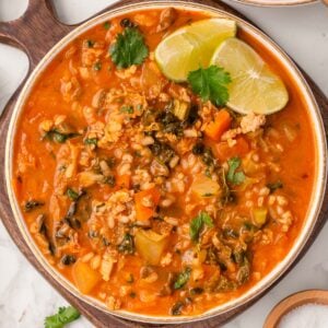 Thai ground turkey soup garnished with lime and cilantro in a bowl.