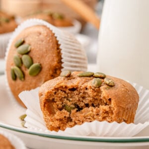 Kodiak pumpkin muffins in parchment paper liners and milk in a jug.