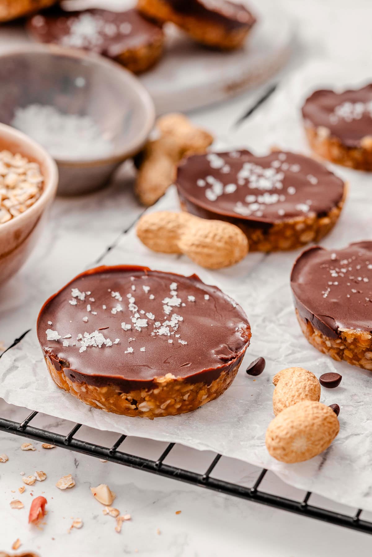 No bake peanut butter oat cups with sea salt on a wire rack.